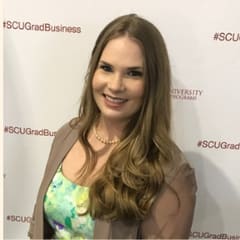 Kelly Scribner of Silicon Valley Bank, in front of a graduate-business step-and-repeat.