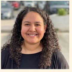 Rebecca Arango of Canvas Credit Union, with curly hair, outdoors.