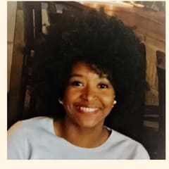 Rosine Bouobda of NEWSED and Enterprise Community Partners, smiling in a white top.
