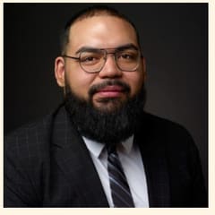 Williams Mendoza, Community Banking at UMB Bank, in glasses and a dark suit.